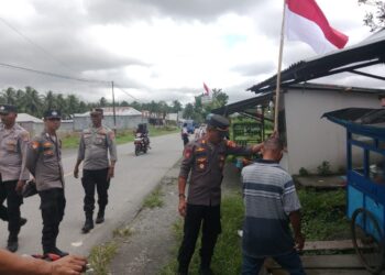 Polsek Waipia Bagikan dan Pasang Bendera Merah Putih untuk Masyarakat